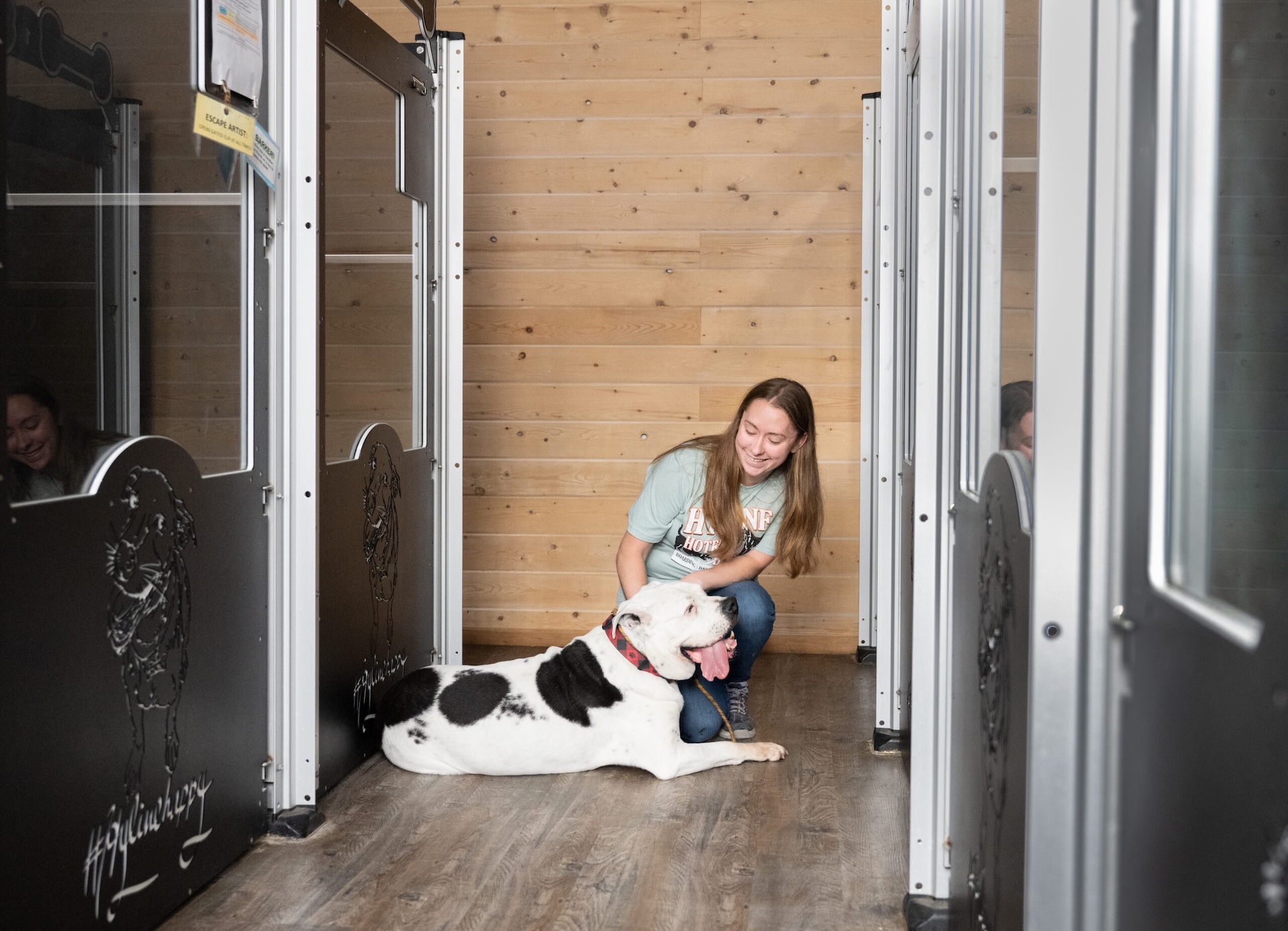 Staff member and dog relaxing outside of dog suites at Hyline Hotel for Dog Boarding near Blaine, WA